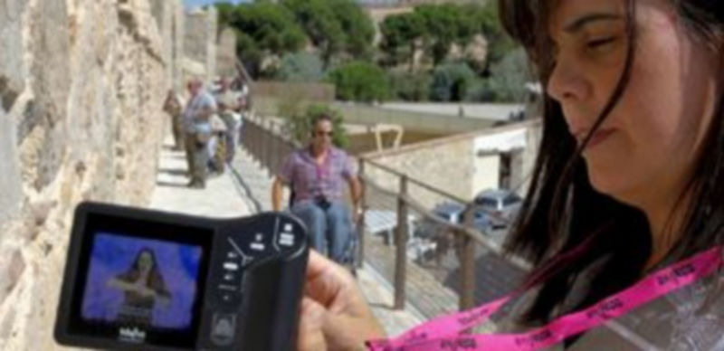 Una mujer muestra la nueva "video-guía" para visitar la muralla de Ávila