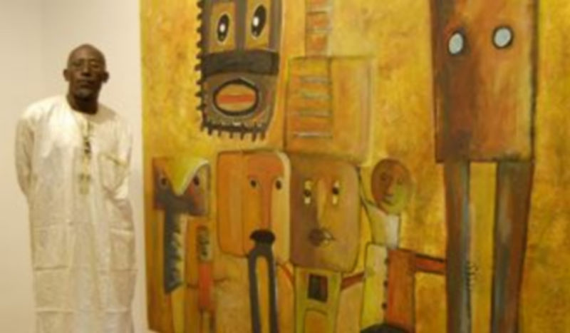 El artista africano posa junto a una de sus obra el día de la inauguración de la muestra que podrá verse hasta el próximo 30 de octubre . / Leandro Valdez