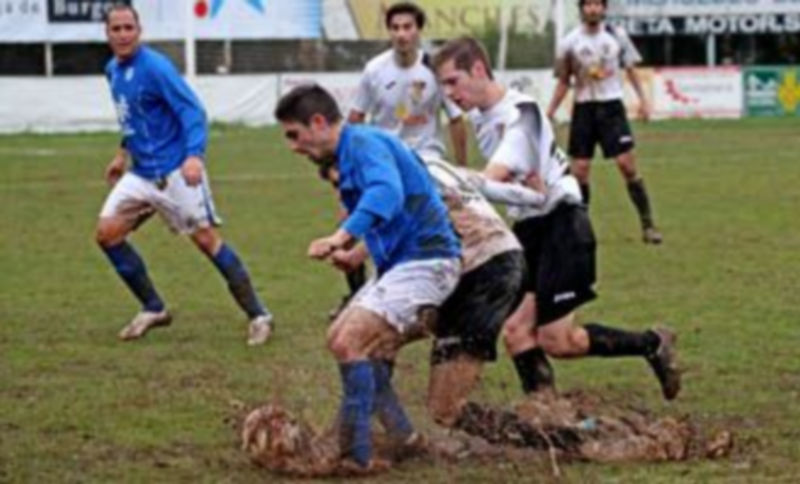 Seta intenta controlar el balón en pleno barrizal ante el acoso de un defensor del Lermeño. / Diario de Burgos