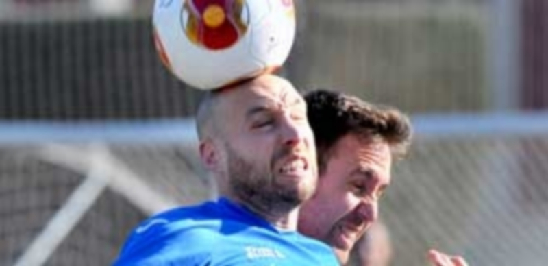 Chiqui y Morales intentan despejar un balón con la cabeza en un momento del encuentro jugado en el campo de El Hospital. / Kamarero