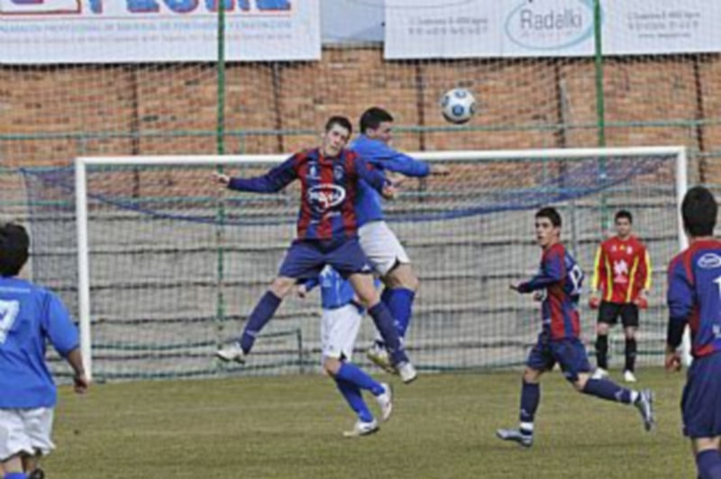 Dos jugadores disputan un balón por alto durante el derbi de ayer entre el Unami y la Gimnástica Segoviana B. / Juan Martín