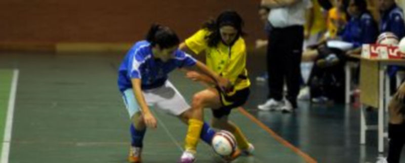 Una jugadora segoviana pasa el balón bajo las piernas de una rival. / Kamarero