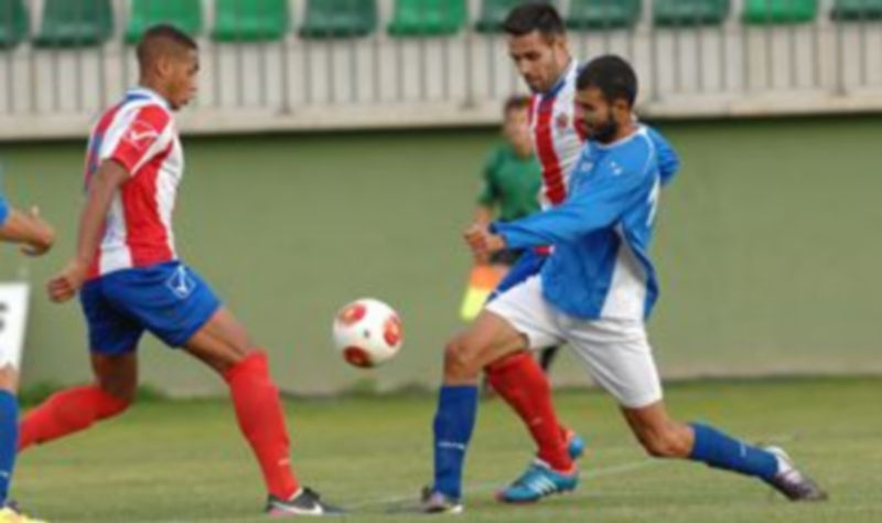 Alex intenta hacerse con un balón en presencia de dos jugadores del Atlético Bembibre. / Lara Mazagatos