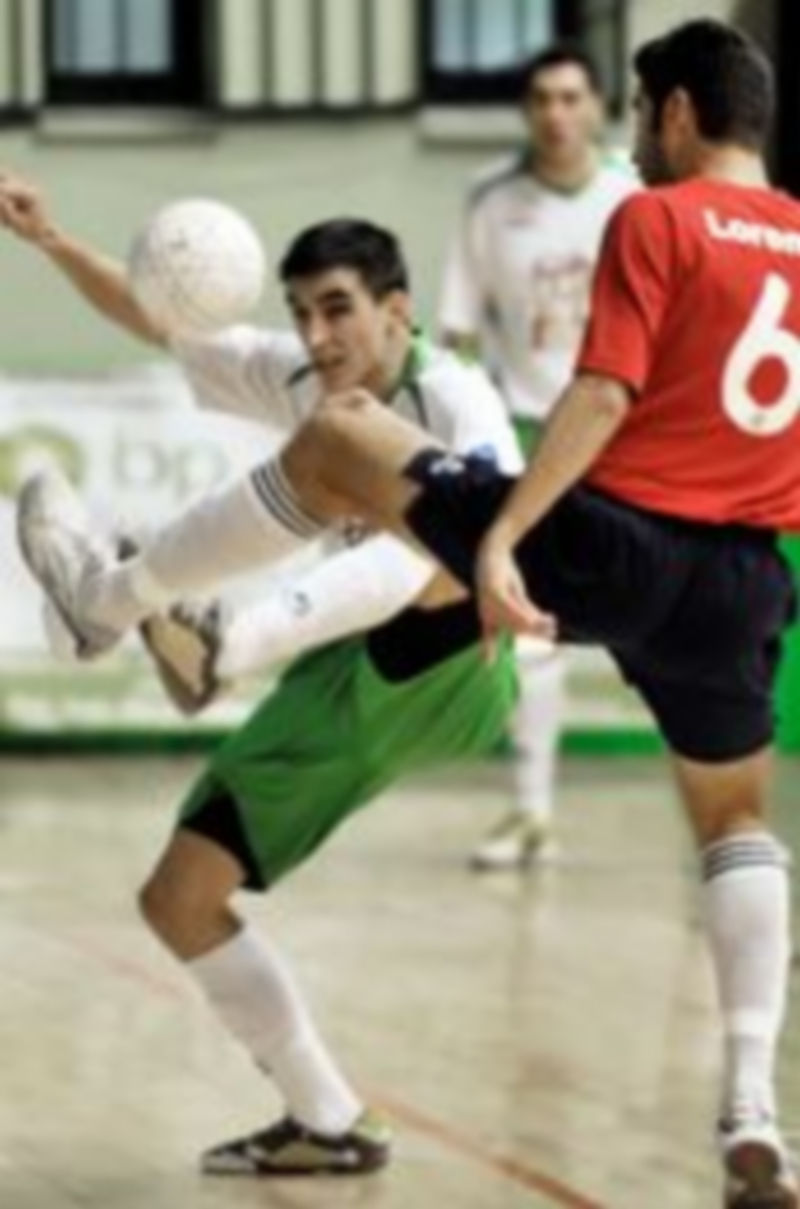 Carlitos y Javi Lorente levantan la pierna para intentar contactar con el balón./KAMARERO