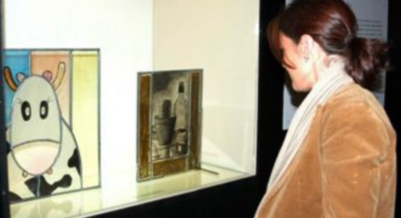 Una mujer contempla una vidrina con los trabajos de los estudiantes de la ESV