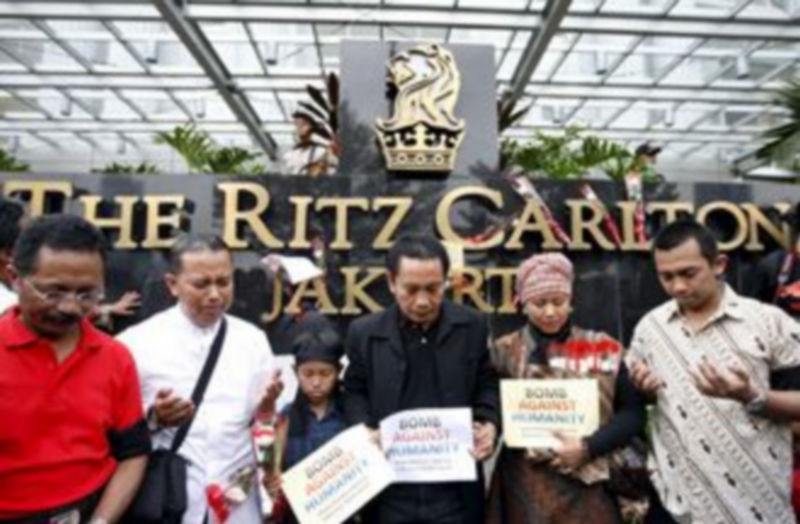 Un grupo de persona reza ante el hotel Ritz