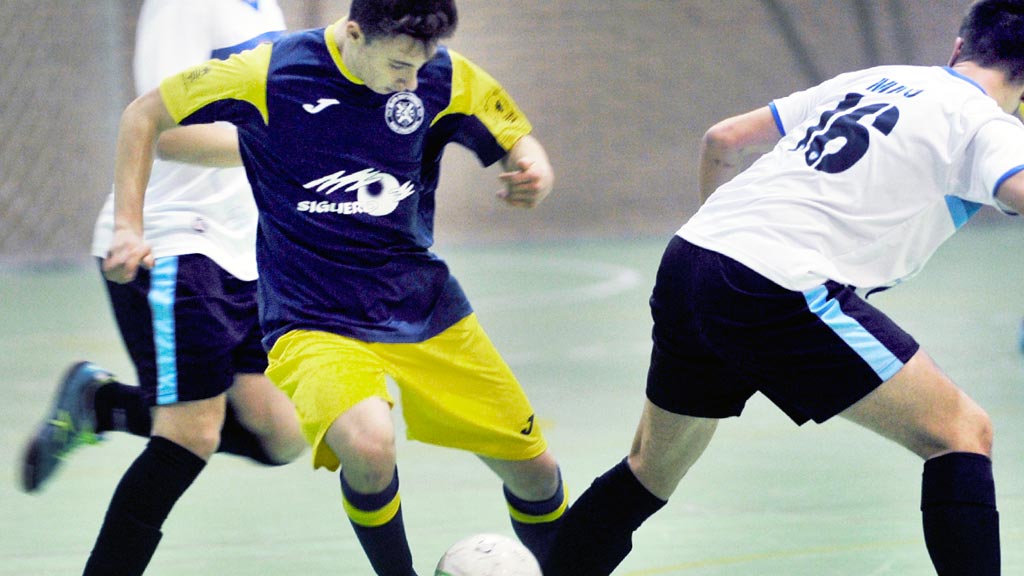 Un jugador del CD San Cristóbal Segovia intenta marcharse de un rival del FS Salamanca durante el partido. / KAMARERO