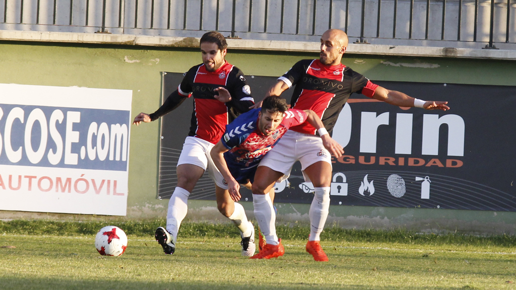 Dos jugadores del Adarve derriban a Fernán. / NEREA LLORENTE
