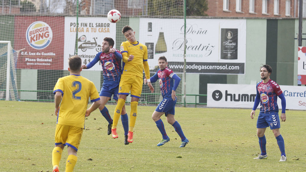 Manu disputa un balón por alto en el amistoso contra el Alcorcón B. / NEREA LLORENTE