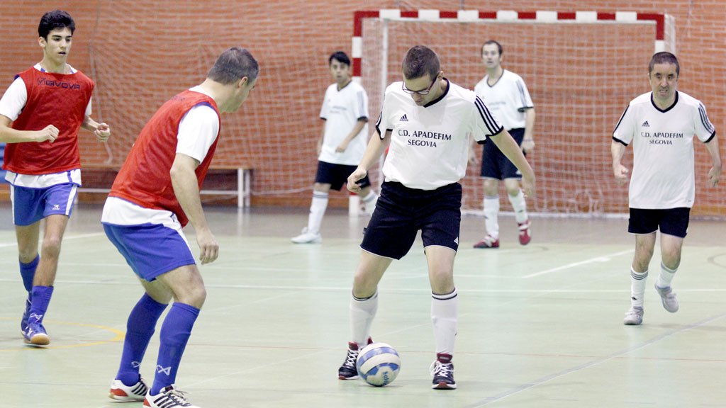 Un jugador del conjunto segoviano del CD Apadefim conduce un balón ante la presión de un rival del Asprona Valladolid. / NEREA LLORENTE