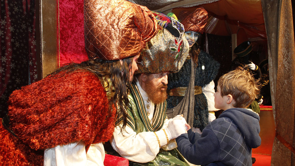 El Rey Gaspar y una de sus asistentes escuchan atentos las peticiones de uno de los niños tras la cabalgata celebrada por las calles de la ciudad. / Nerea Llorente