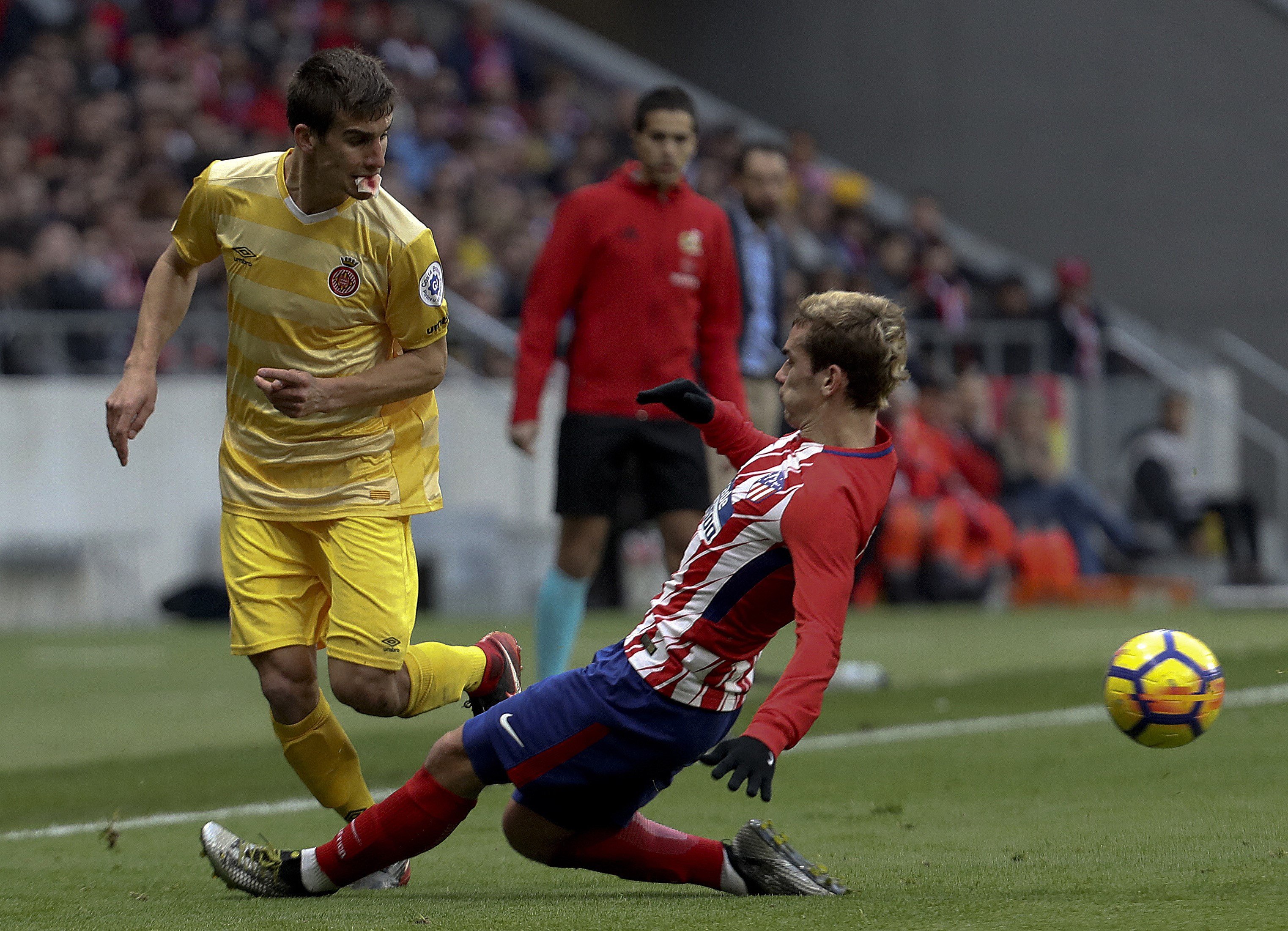 El delantero francés del Atlético de Madrid Antoine Griezmann pelea el balón frente al jugador del Girona Pere Pons .