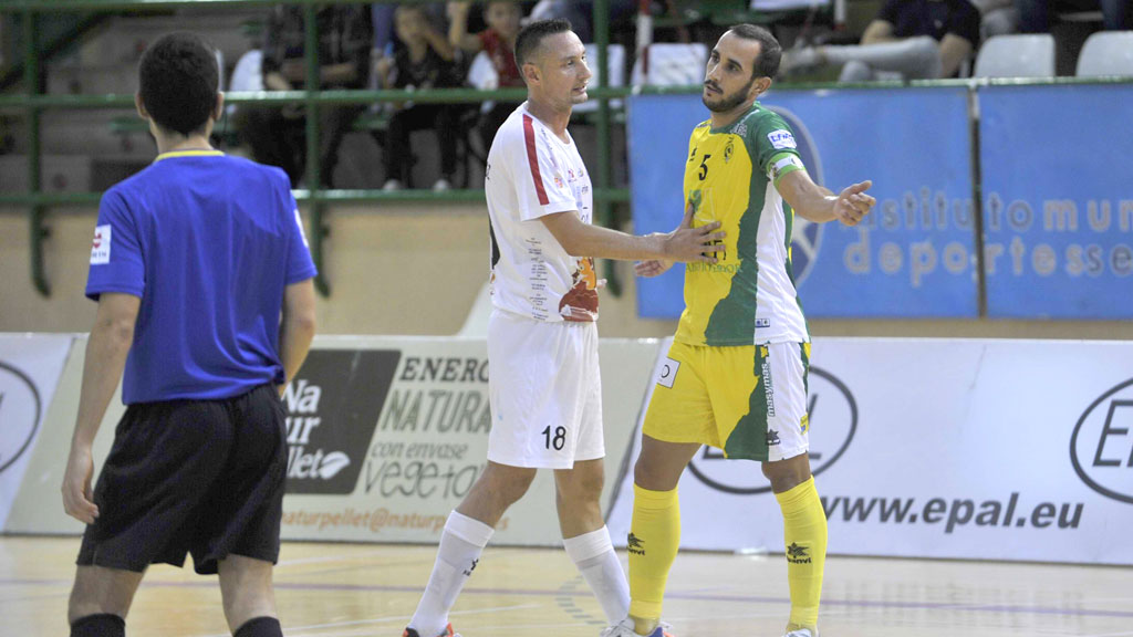 Carlos Muñoz sujeta a un jugador del Jaén durante el encuentro jugado en la primera vuelta. / KAMARERO