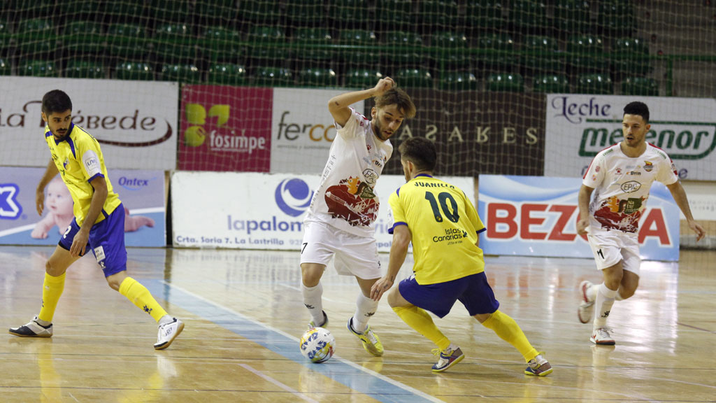 El jugador del Naturpellet Segovia Álvaro López intenta marcharse de la presión del rival Juanillo. / NEREA LLORENTE