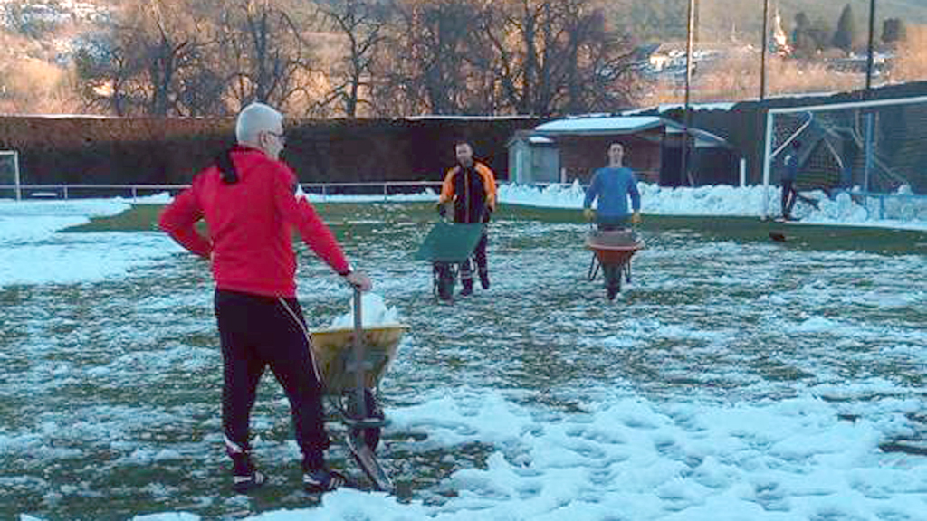 La Regional recupera su actividad salvo sorpresas de última hora 1 Los componentes del CD La Granja retiran la nieve sobre el campo de El Hospital para jugar esta tarde. / CD LA GRANJA
