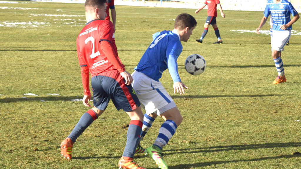 Dani Lázaro disputa un balón bajo la presión de Alejandro, del Norma. / M.HERRERO