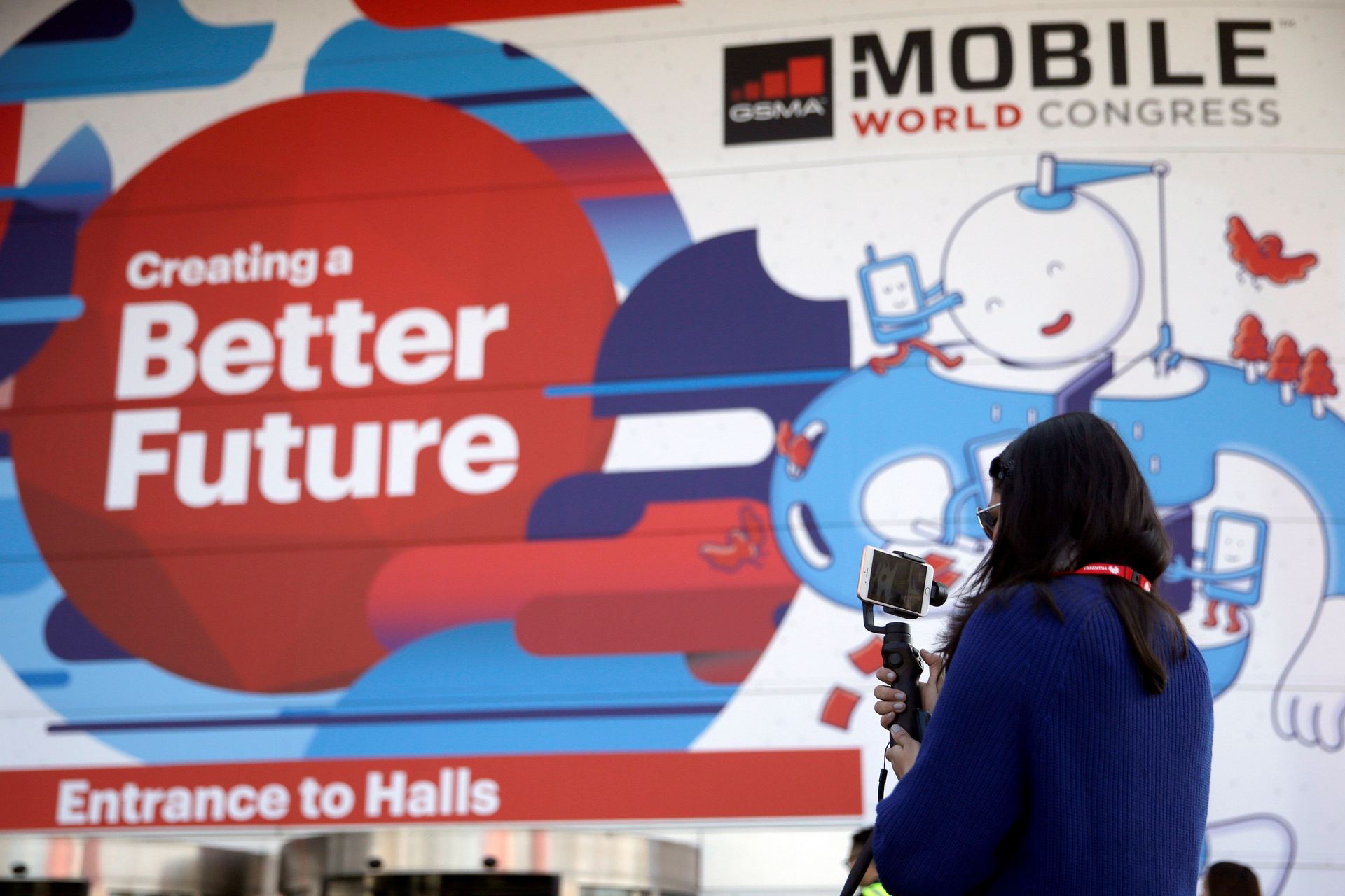 Una vistante hace una foto ante la entrada de la Fira Gran Via donde a partir de mañana se celebra una nueva edición del Congreso Mundial de Móviles.