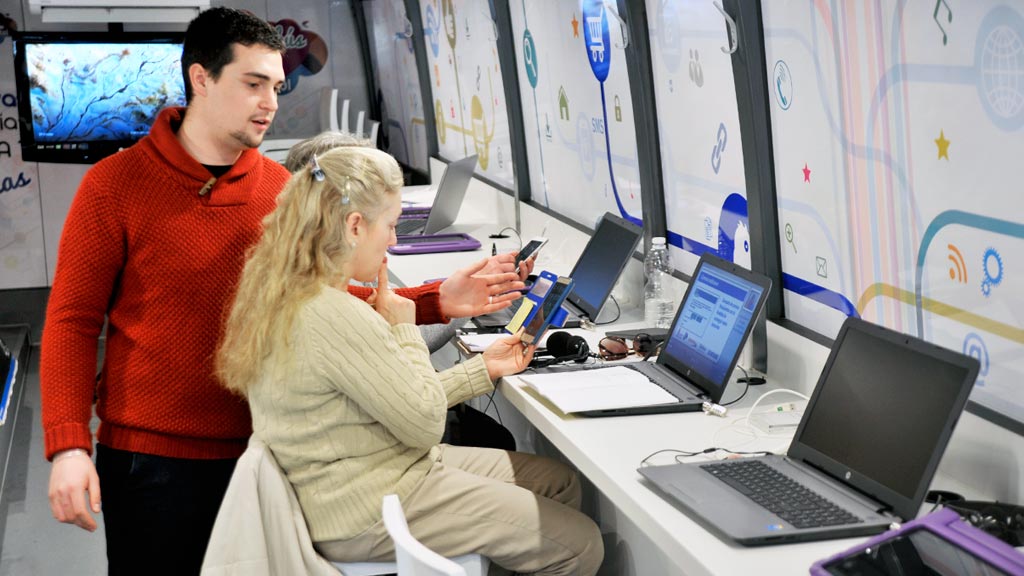 Una usuaria atiende las explicaciones del técnico, ante su portátil. / kamarero