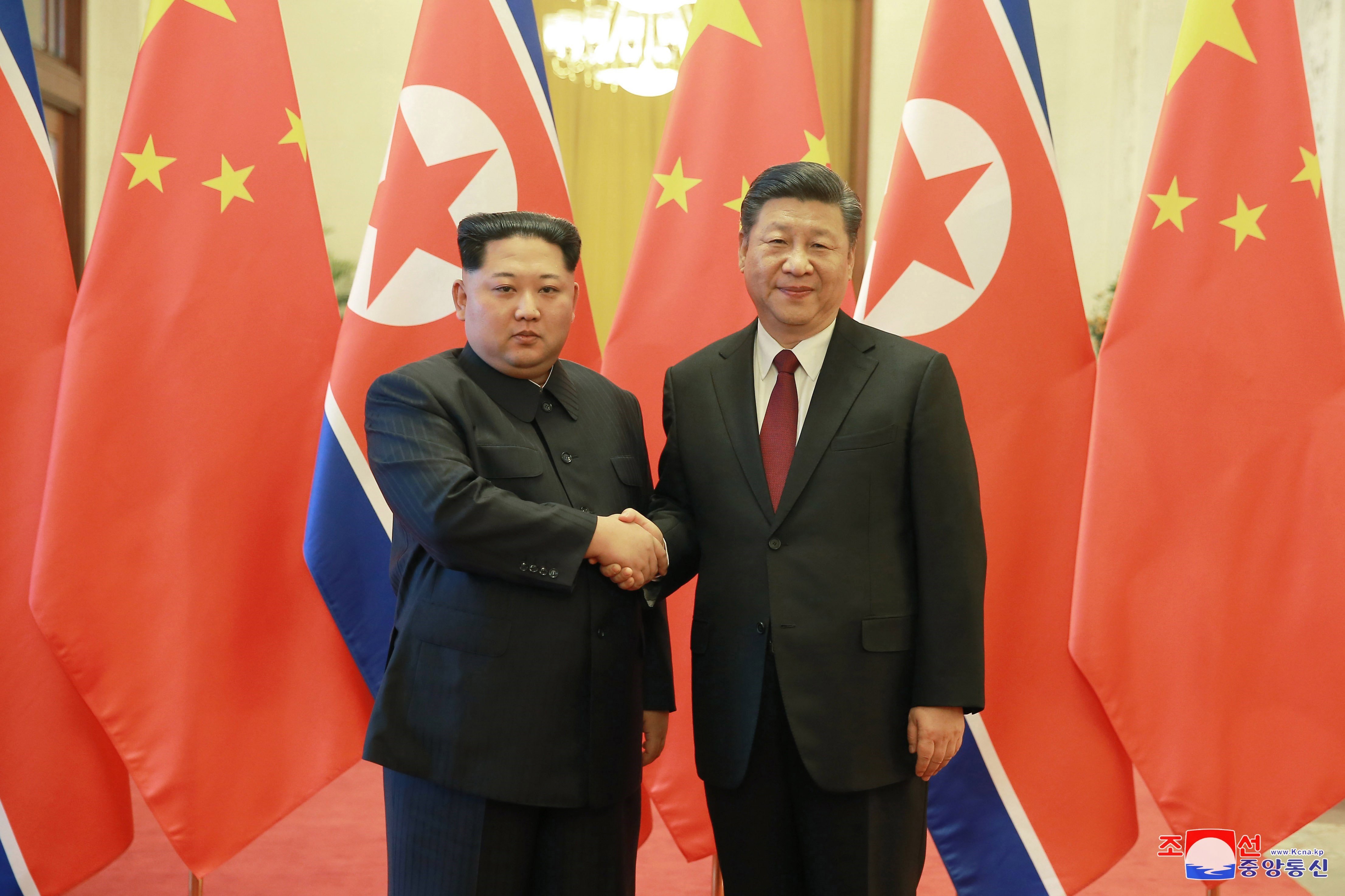 El líder norcoreano, Kim Jong-un (i), y el presidente chino, Xi Jinping posan ante los medios de comunicación.