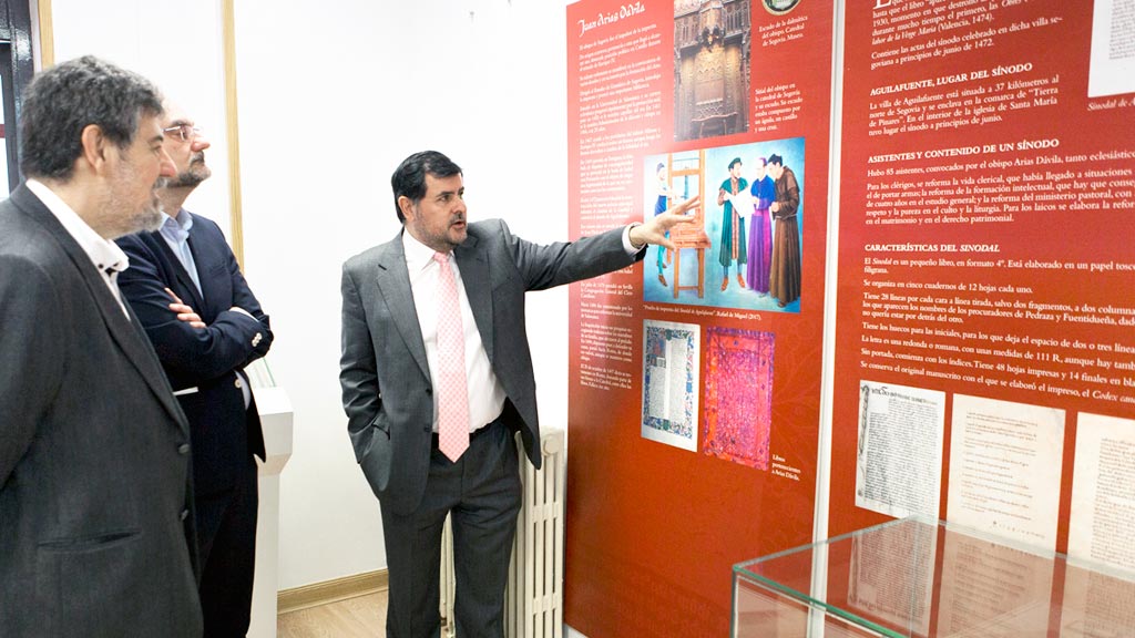 Fermín de los Reyes muestra la exposición a dos expertos asistentes a las jornadas. / el adelantado