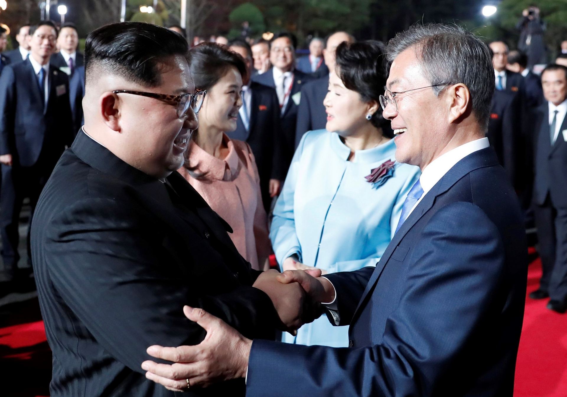 El líder norcoreano Kim Jong-un estrechando la mano al presidente surcoreano, Moon Jae-in junto a sus esposas.