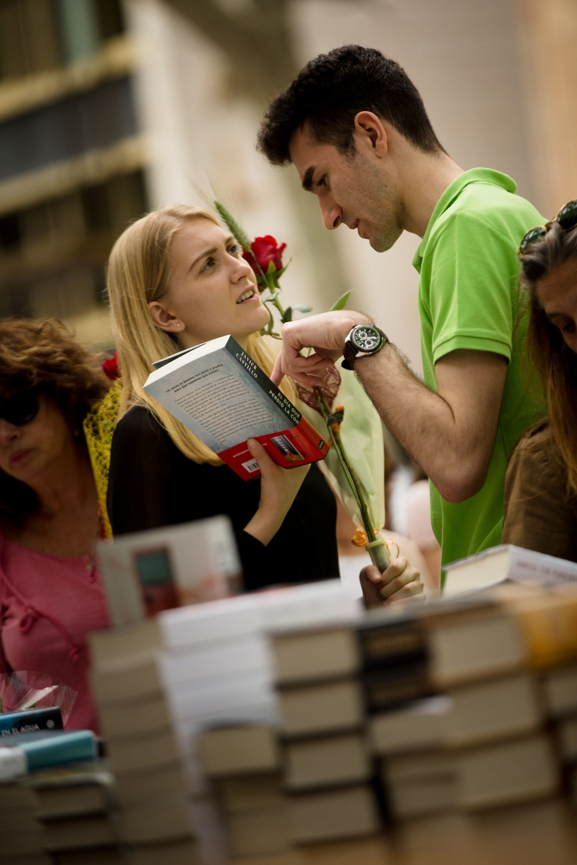 Dos jóvenes cumplen la tradición de regalar rosas y libros por Sant Jordi.