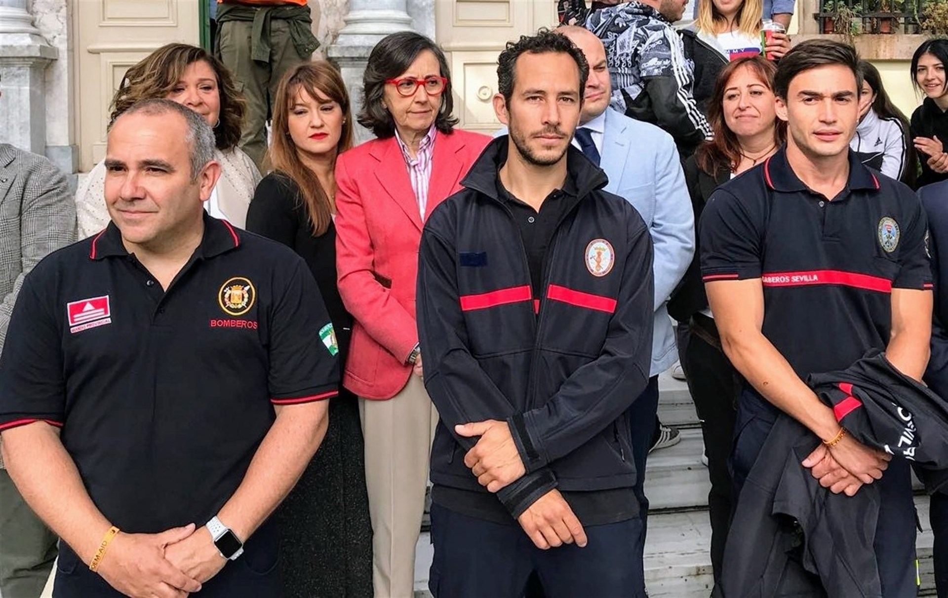 Los tres bomberos españoles posando ante los medios de comunicación minutos antes del juicio en Lesbos.