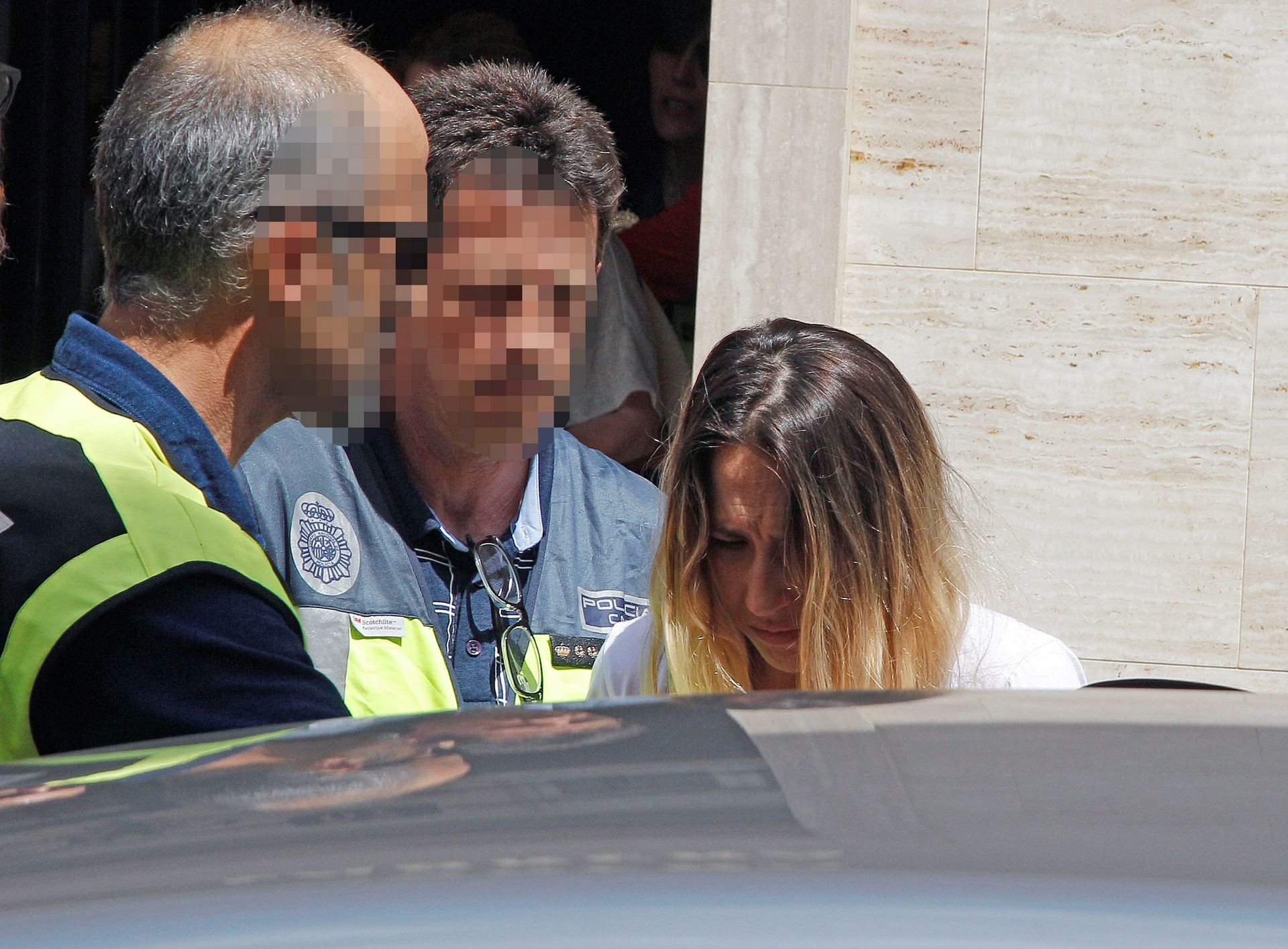 La mujer detenida sale de su domicilio acompañada por la Policía tras uno de los registros practicados.