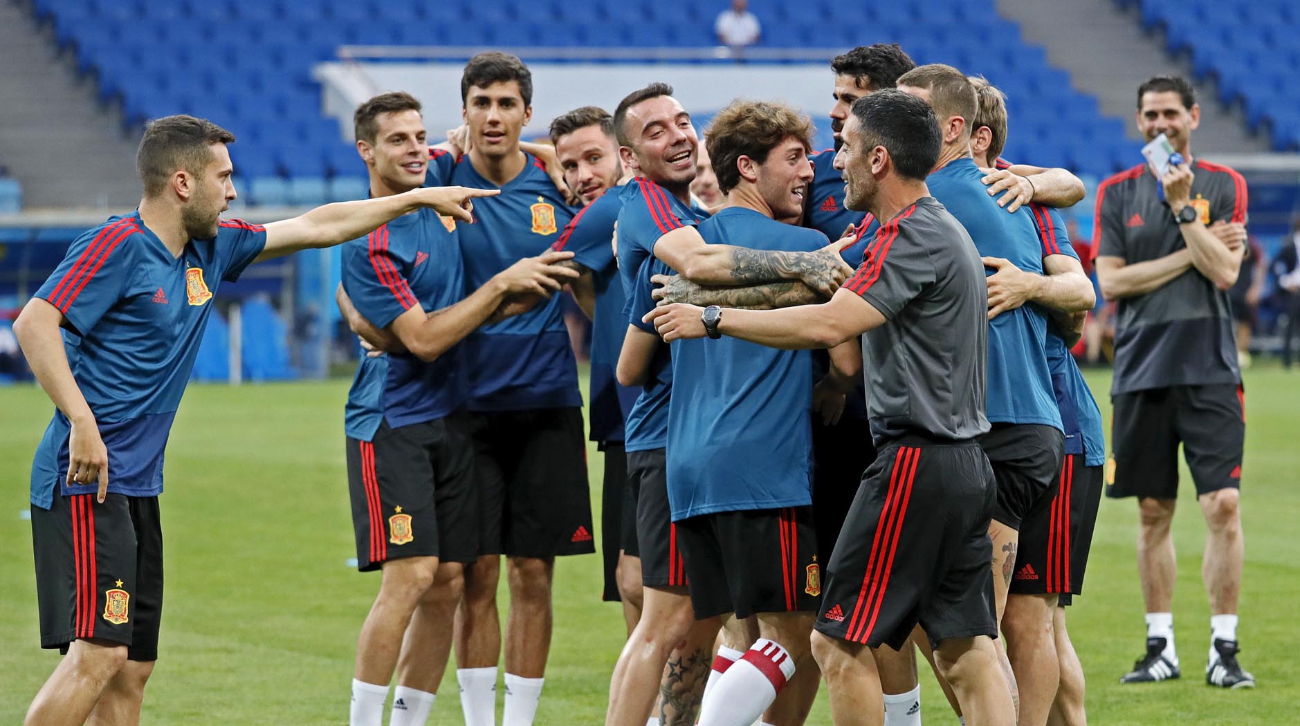 Los jugadores de la Selección Española se abrazan durante un ejercicio del último entrenamiento antes de debutar ante Portugal, con el nuevo seleccionador, Fernando Hierro, al fondo.