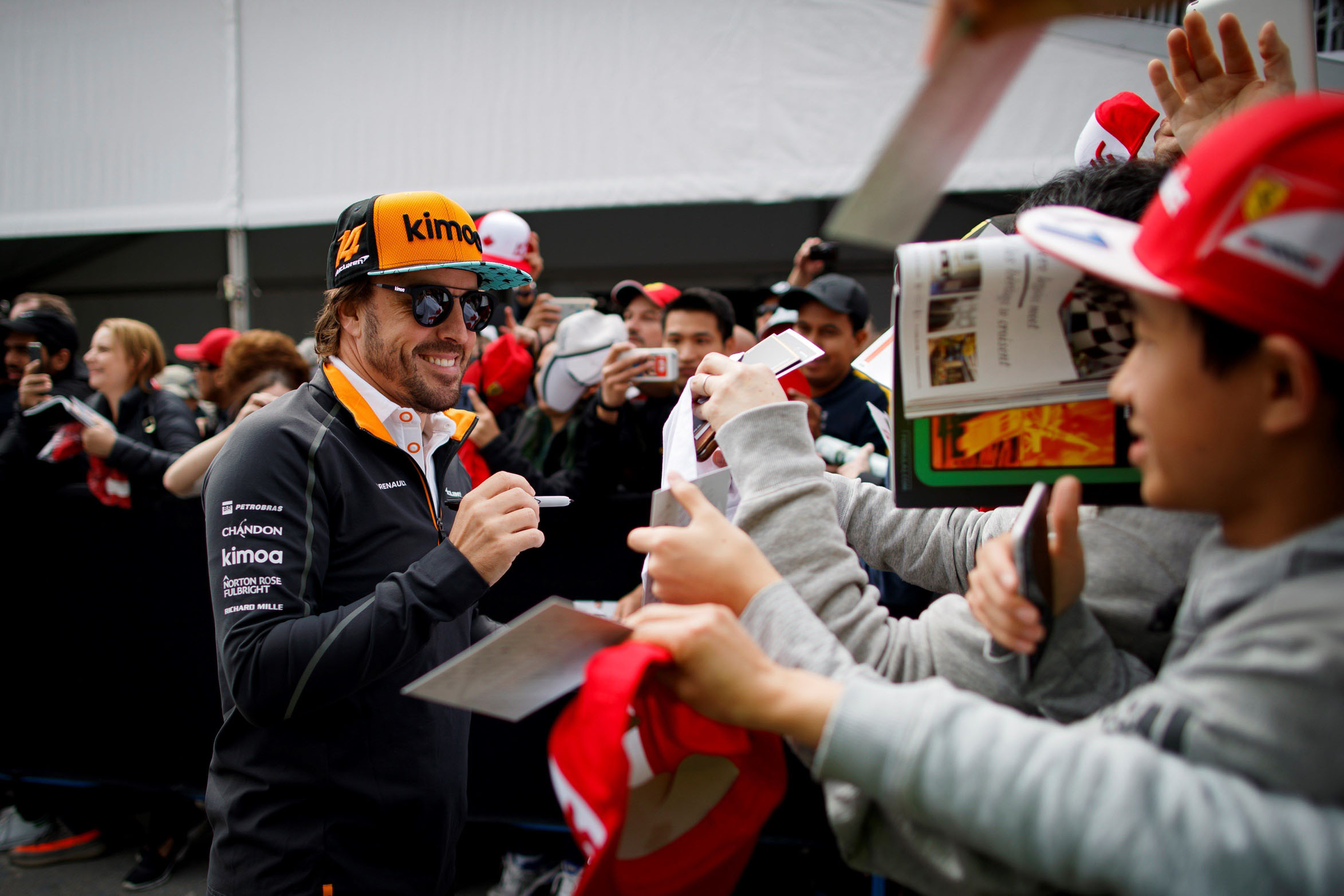 Fernando Alonso firma autógrafos a los aficionados en Montreal.