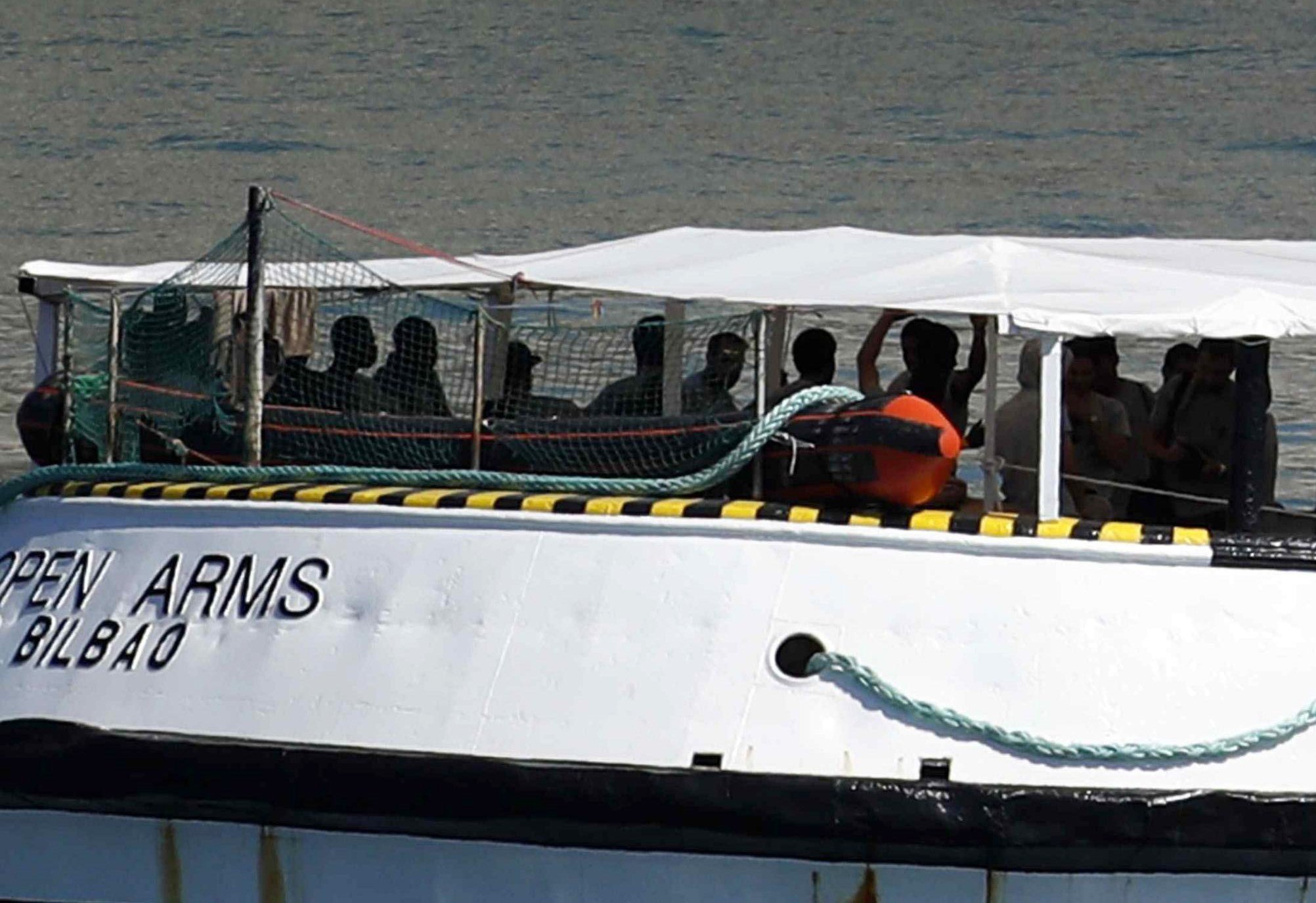 Los migrantes a bordo del Open Arms festejan su llegada al puerto de Barcelona.