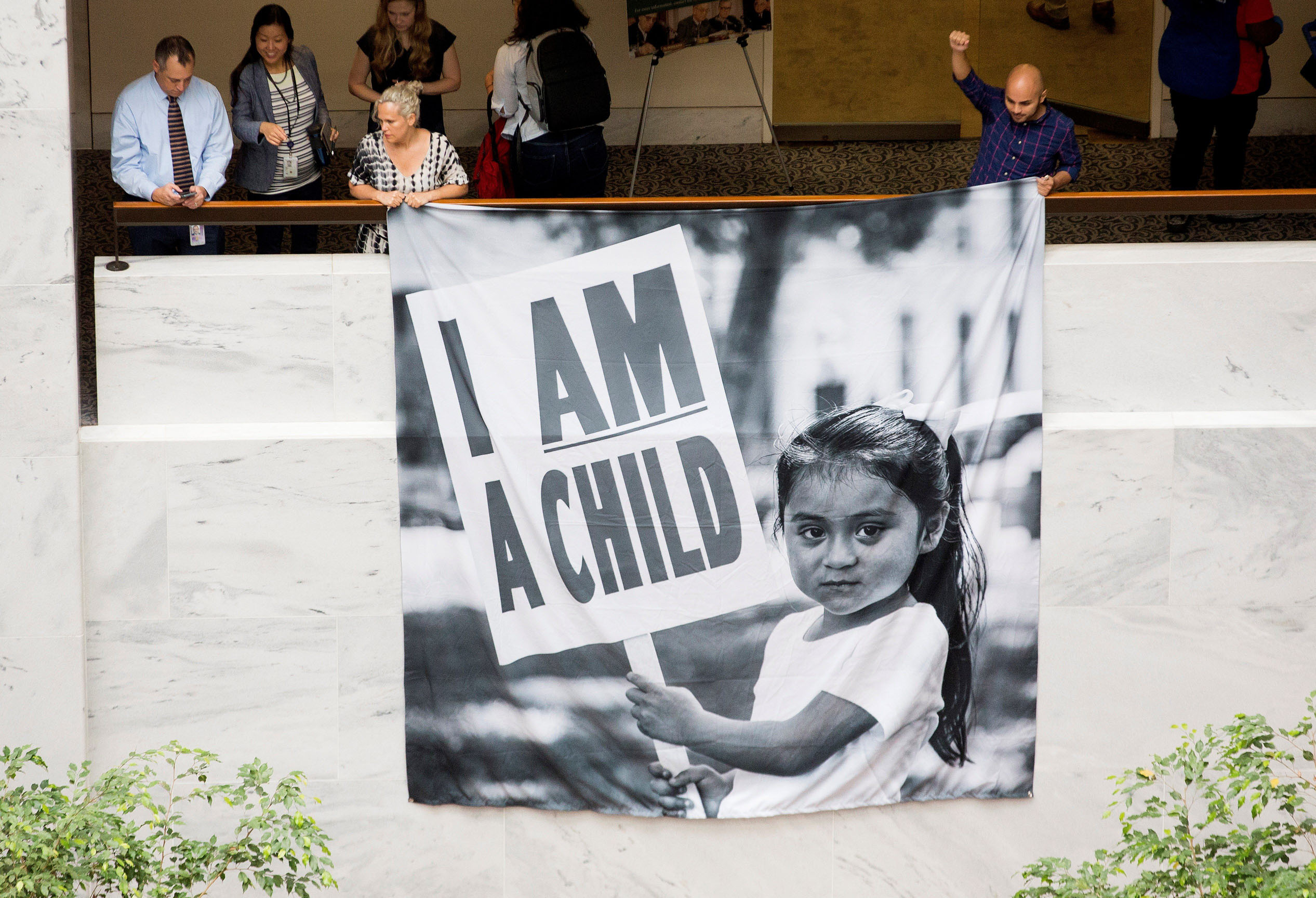 Varias personas participan en una sentada para demandar a la administración Trump la reunificación de las familias.