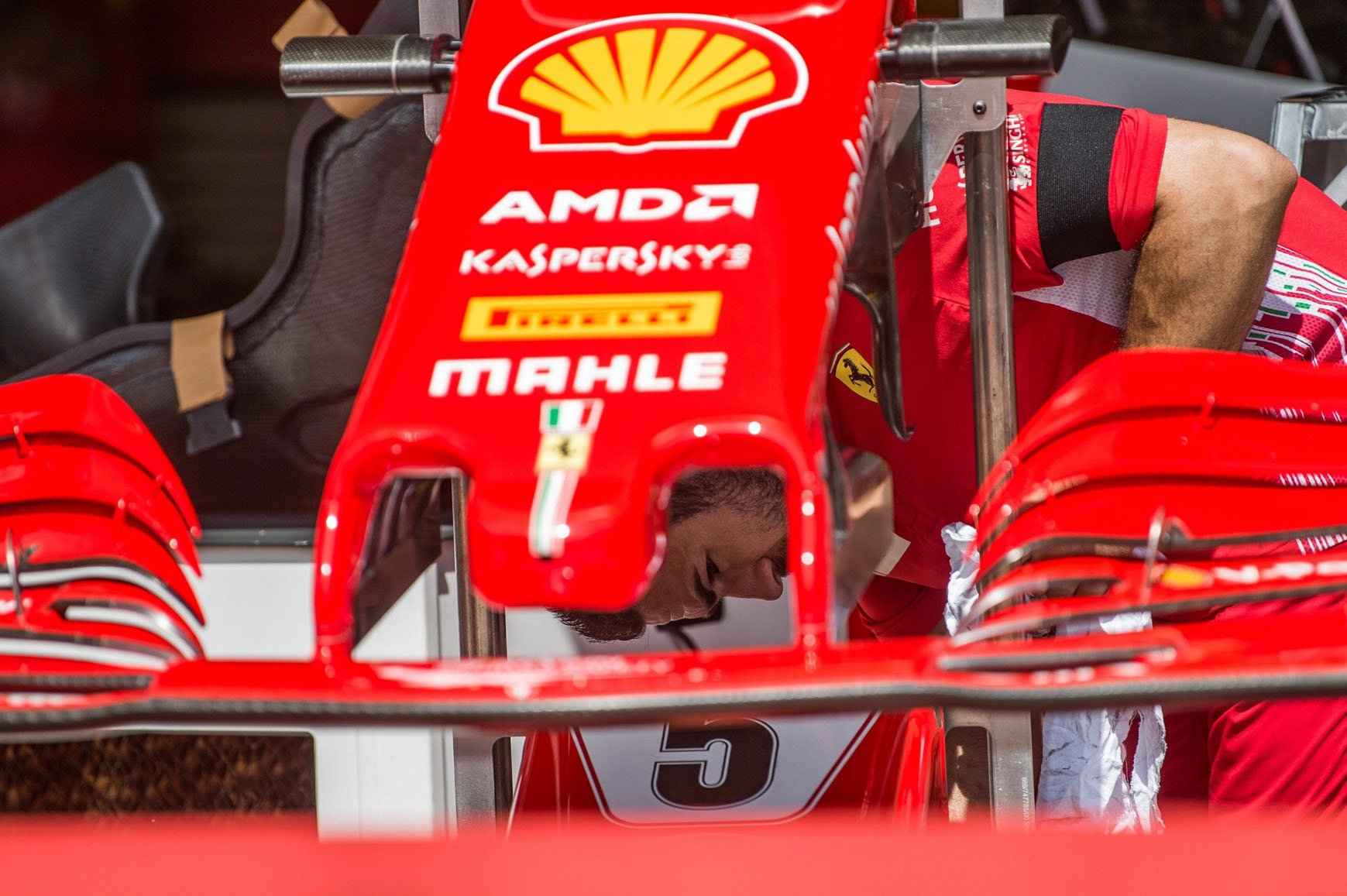 Un mecánico de Ferrari, con un brazalete negro por la muerte de Sergio Marchionne, prepara el coche de Vettel.