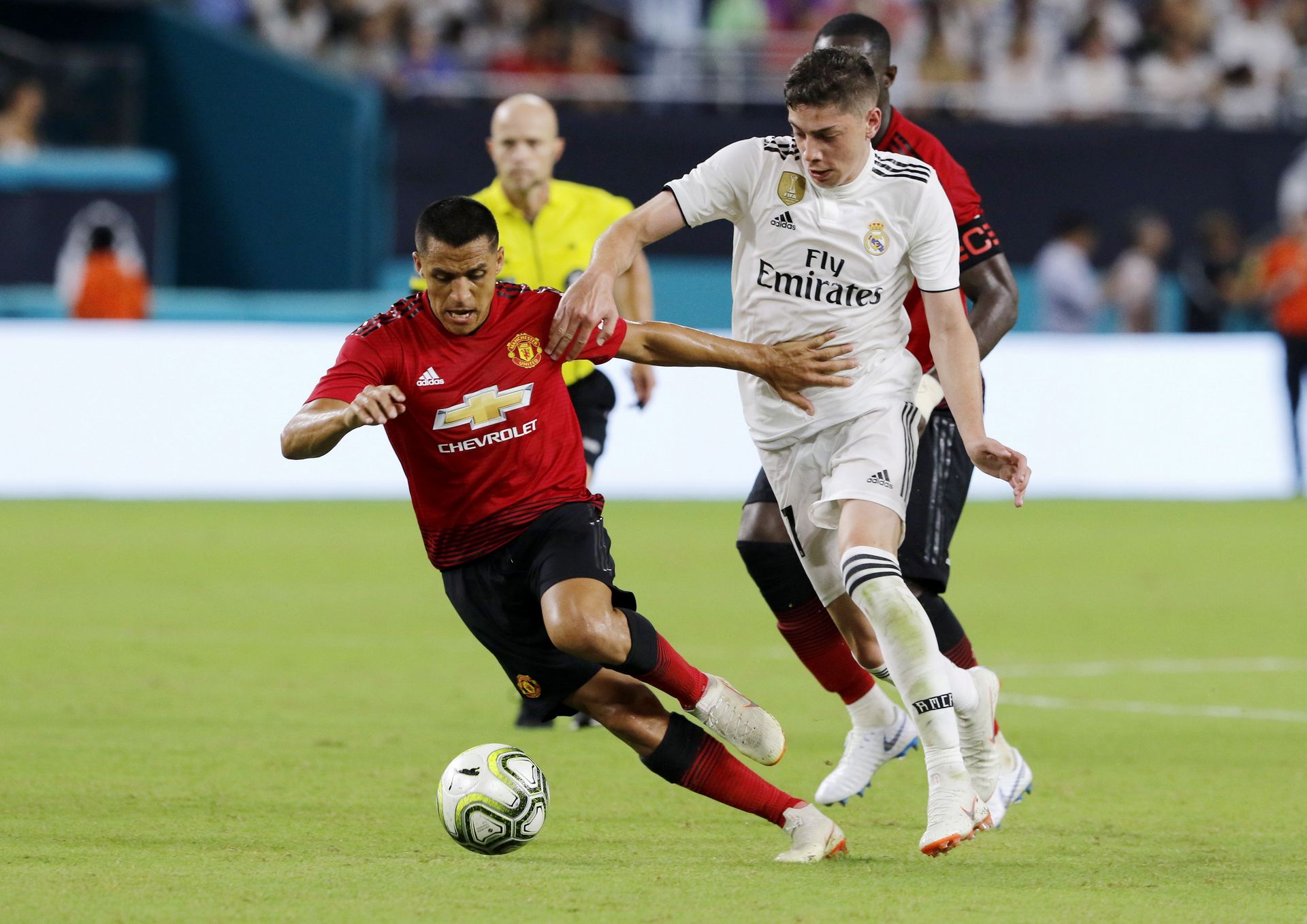 El madridista Federico Valverde intenta atajar al delantero del Manchester United Alexis Sánchez. / EFE