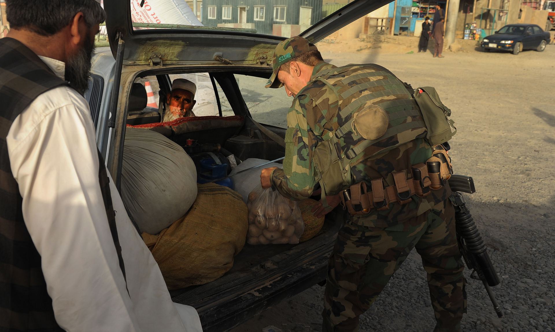 Un soldado afgano realiza el registro de un vehículo en la autopista de Kabul.