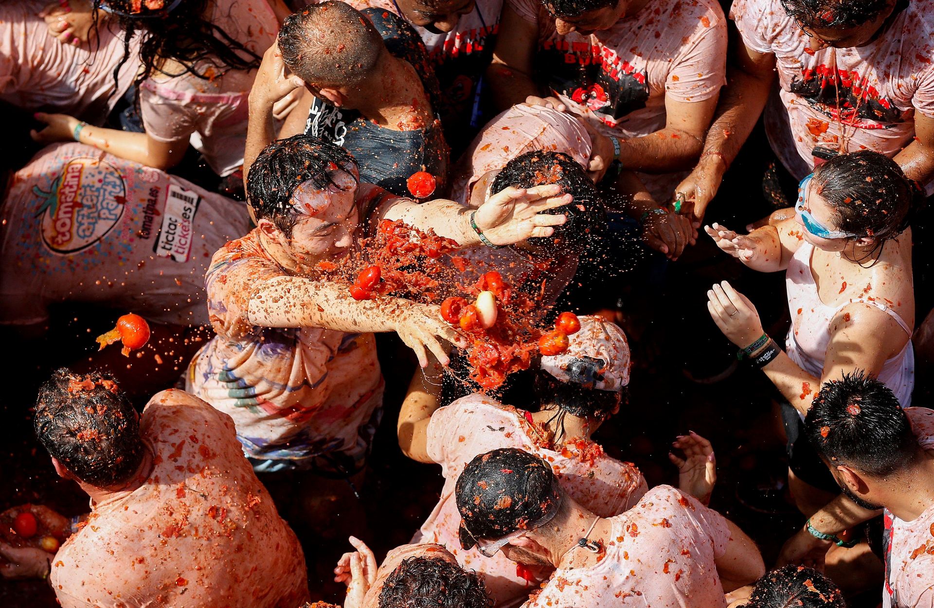 Intantánea de varios asistentes a la Tomatina disfrutando del lanzamiento de tomates.