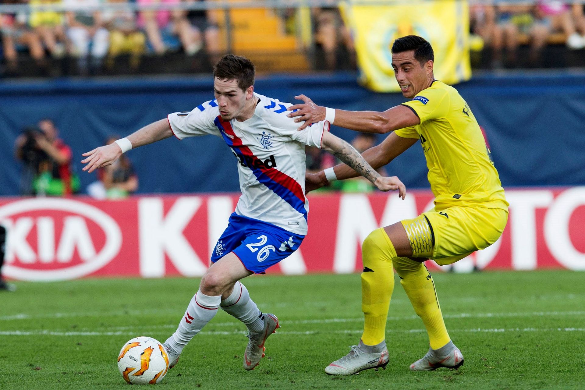 El defensa argentino del Villarreal Ramiro Funes intenta detener el empuje de Ryan Kent, del Rangers.