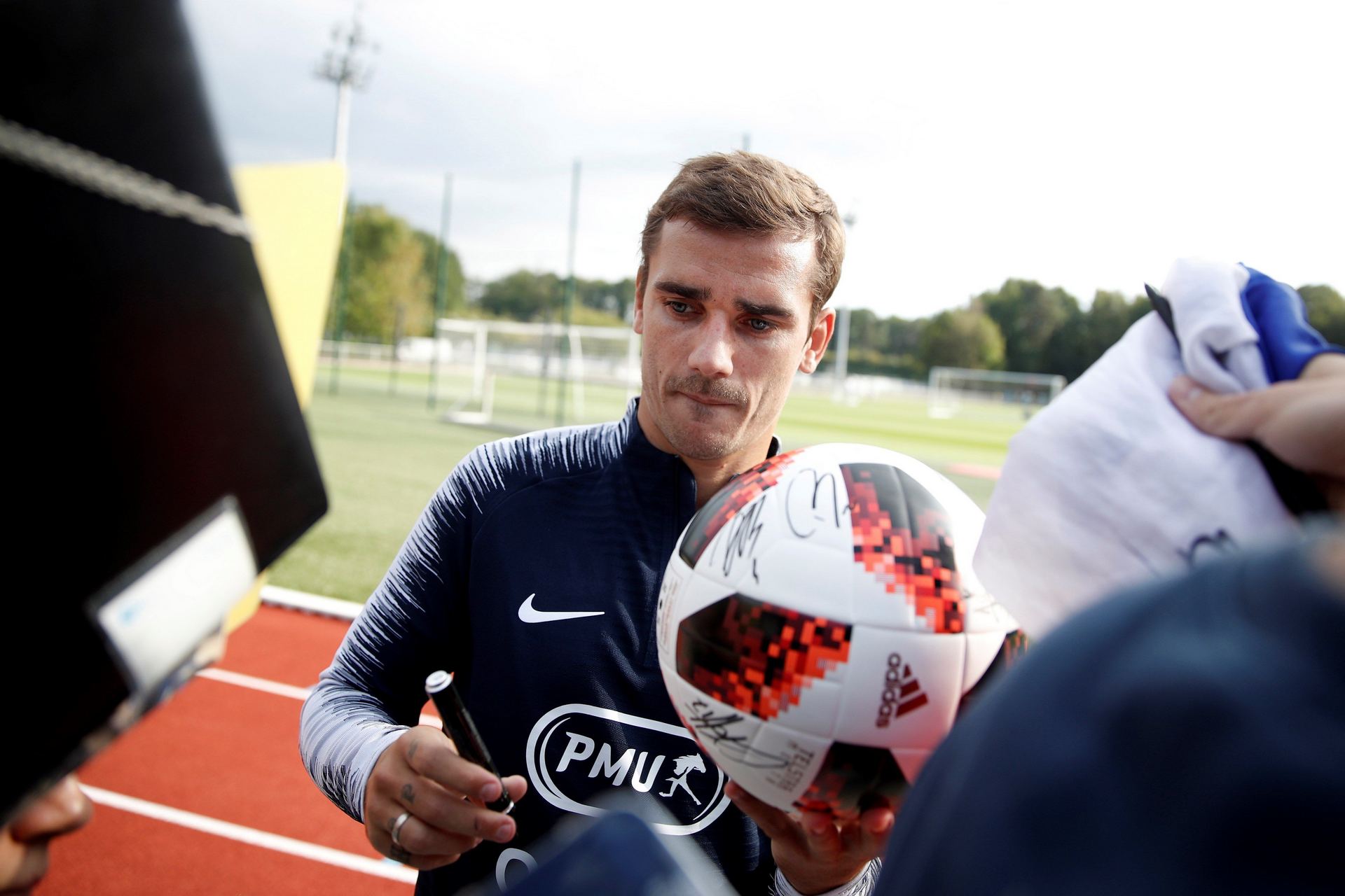 El jugador de la selección nacional de fútbol francesa Antoine Griezmann firma autógrafos en el entrenamiento.