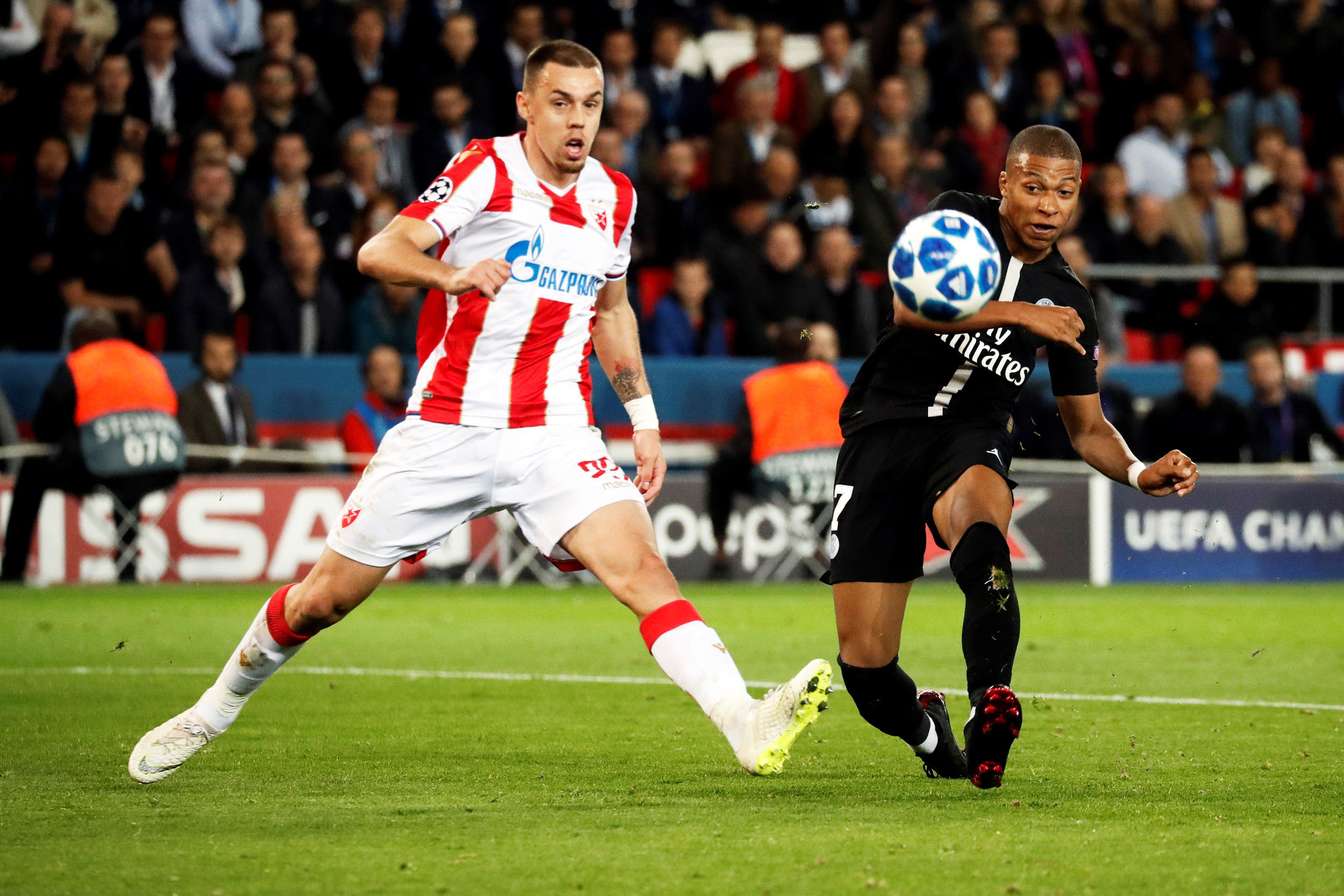 Kylian Mbappe (dcha) golpea el balón ante Milan Rodic durante el partido de Champions entre PSG y Estrella Roja.