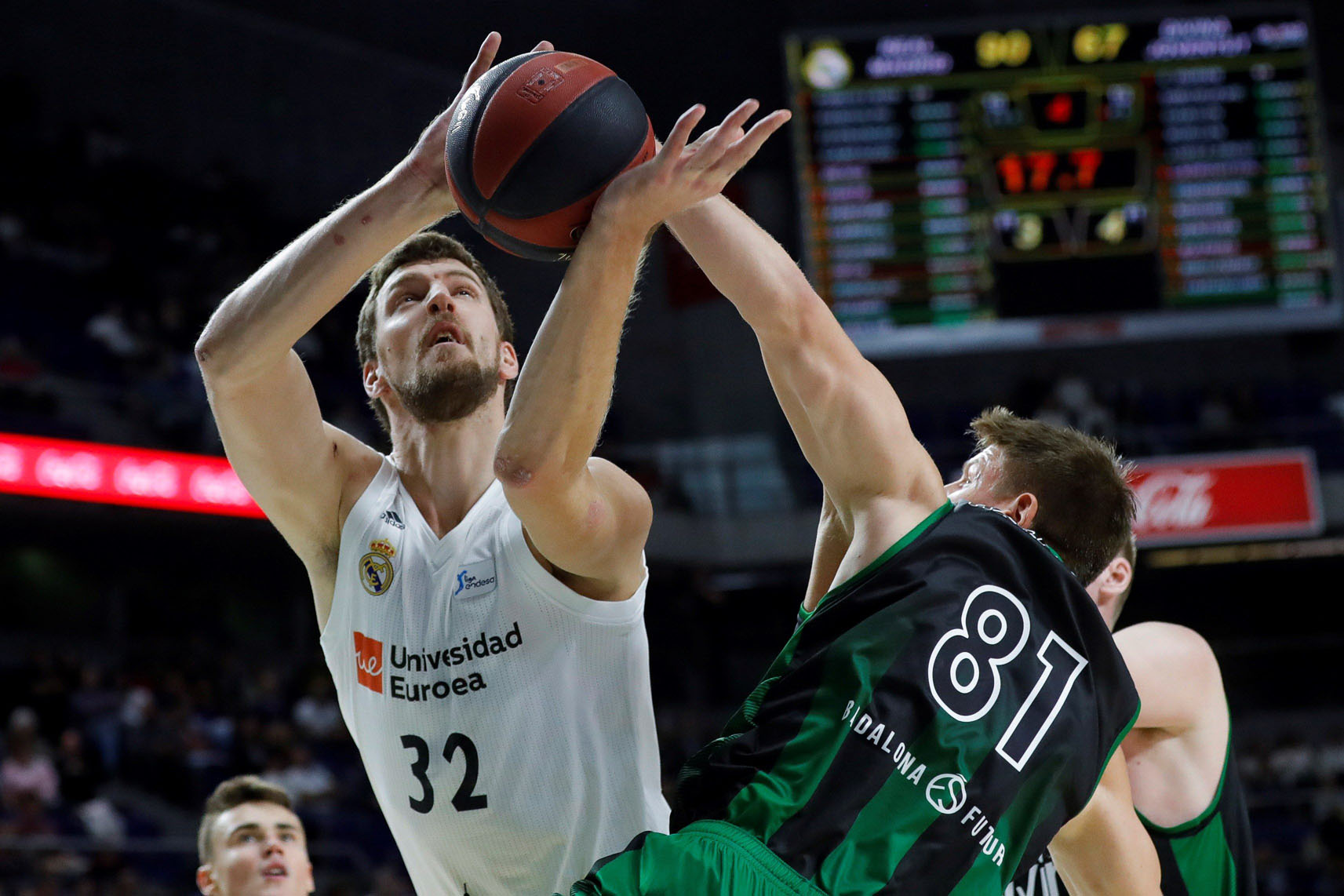 El madridista Ognjen Kuzmic intenta anotar ante la defensa de Luke Harangody, del Divina Seguros Joventut.