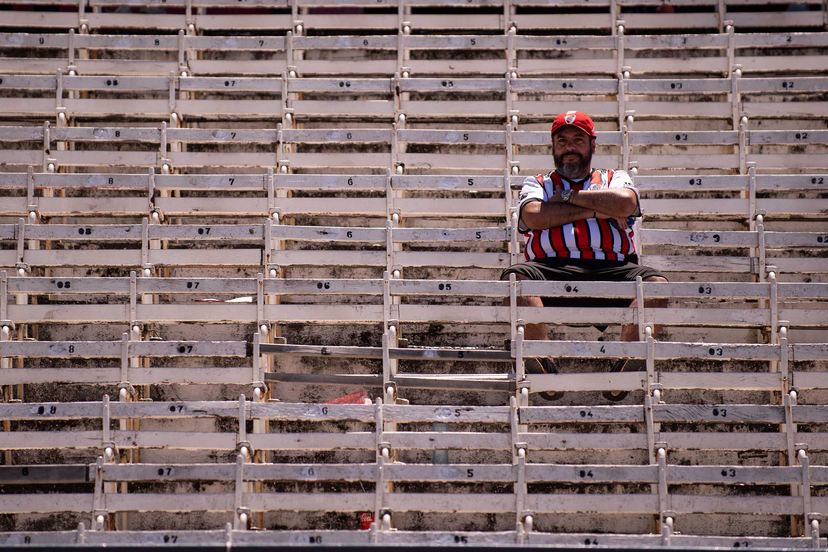 Un aficionado de River Plate espera en una tribuna del estadio Monumental.