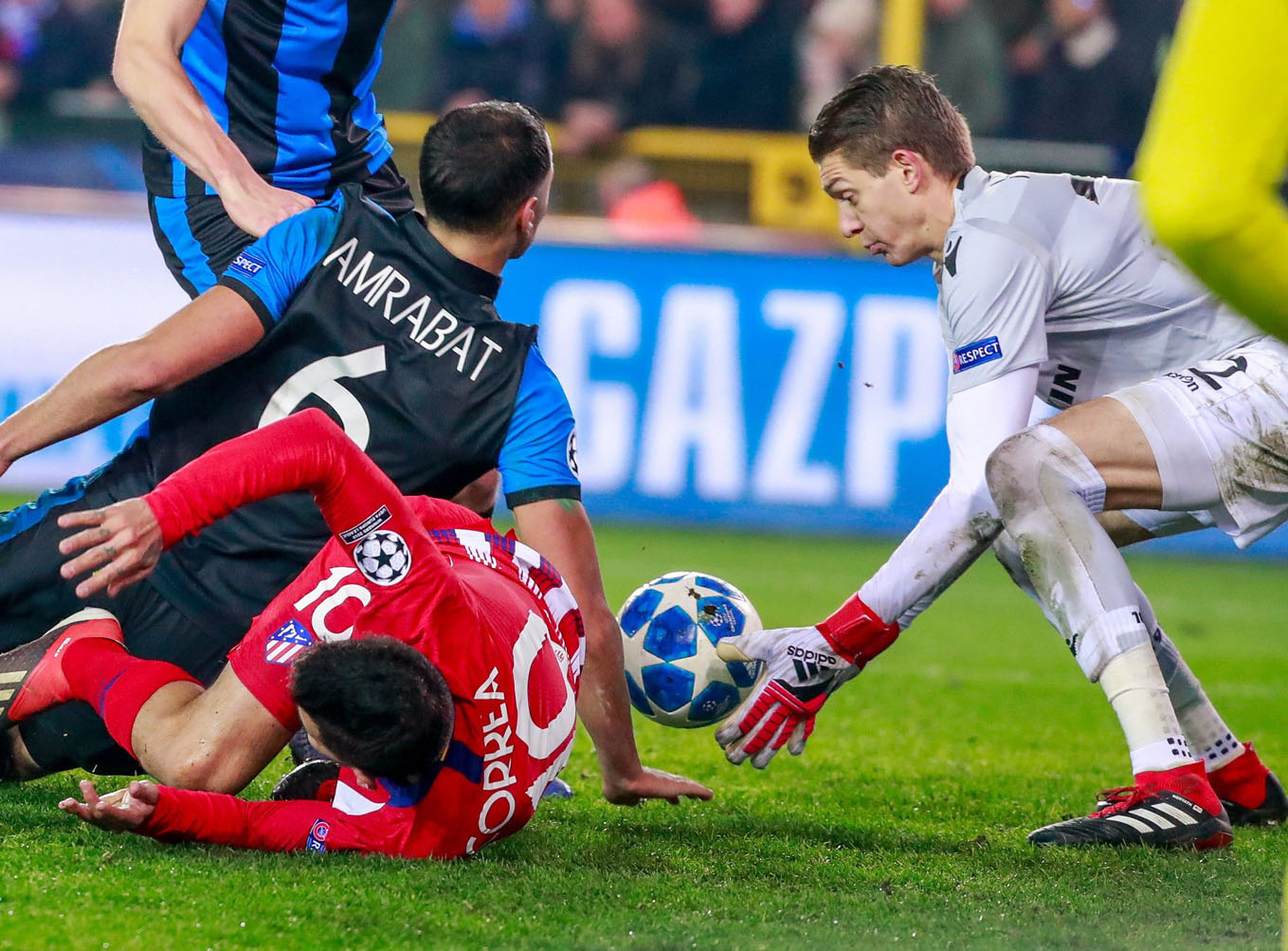 Ángel Correa cae ante Amrabat y Horvath, portero del Brujas.