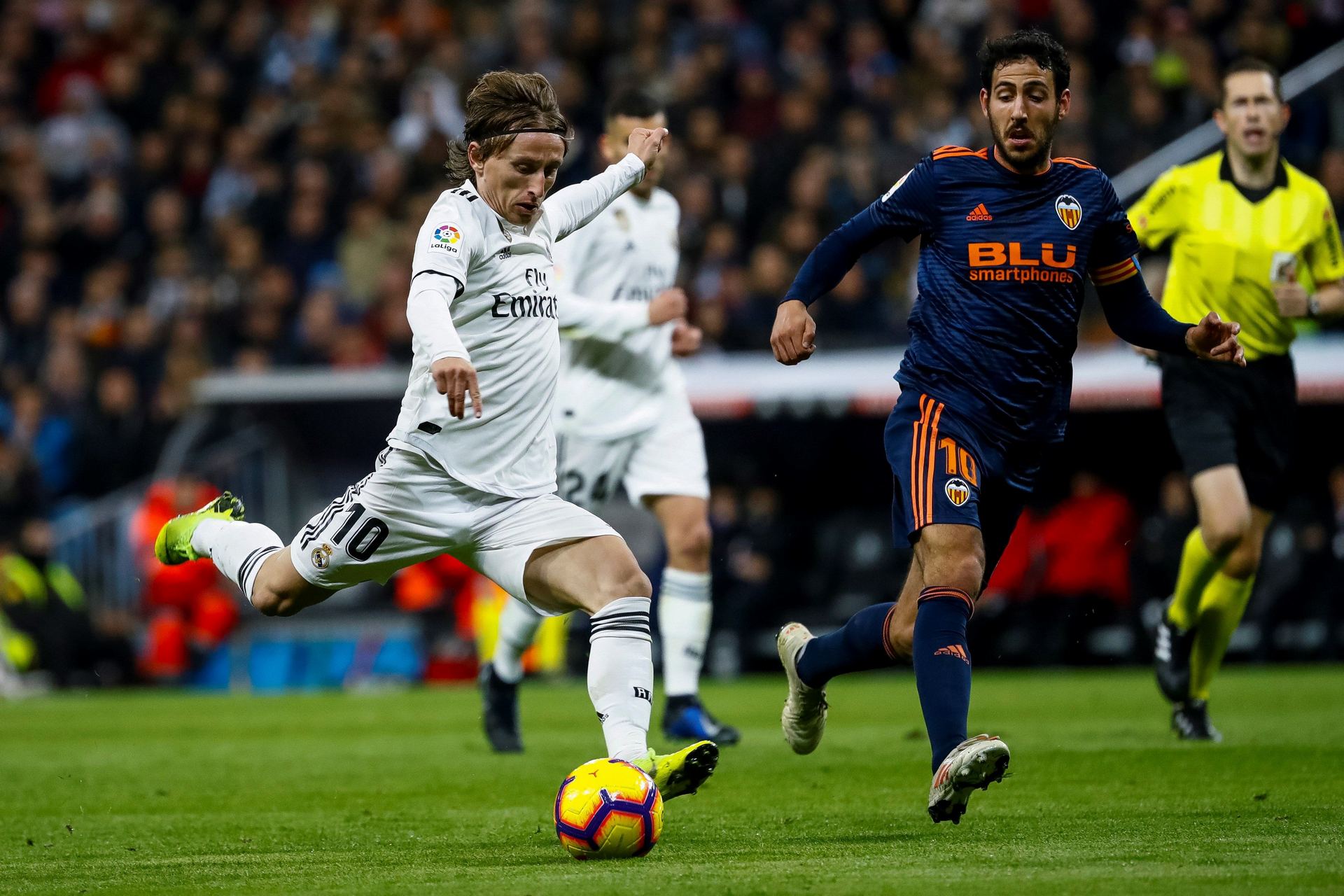 El centrocampista merengue, Modric, se dispone a golpear el balón ante el jugador del Valencia, Dani Parejo.