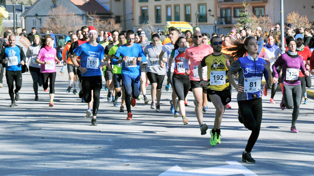 Salida de la carrera absoluta de la San Silvestre de La Granja, con David López y Abraham Tapias en primera línea, desde el entorno de la pradera del campo de fútbol de El Hospital. / KAMARERO