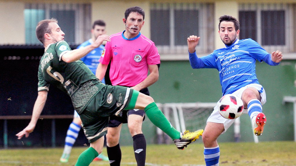 Guty intenta cortar el envío de Marcos sobre un compañero en una acción del encuentro que granjeños y maragatos disputaron en el campo de El Hospital. / KAMARERO