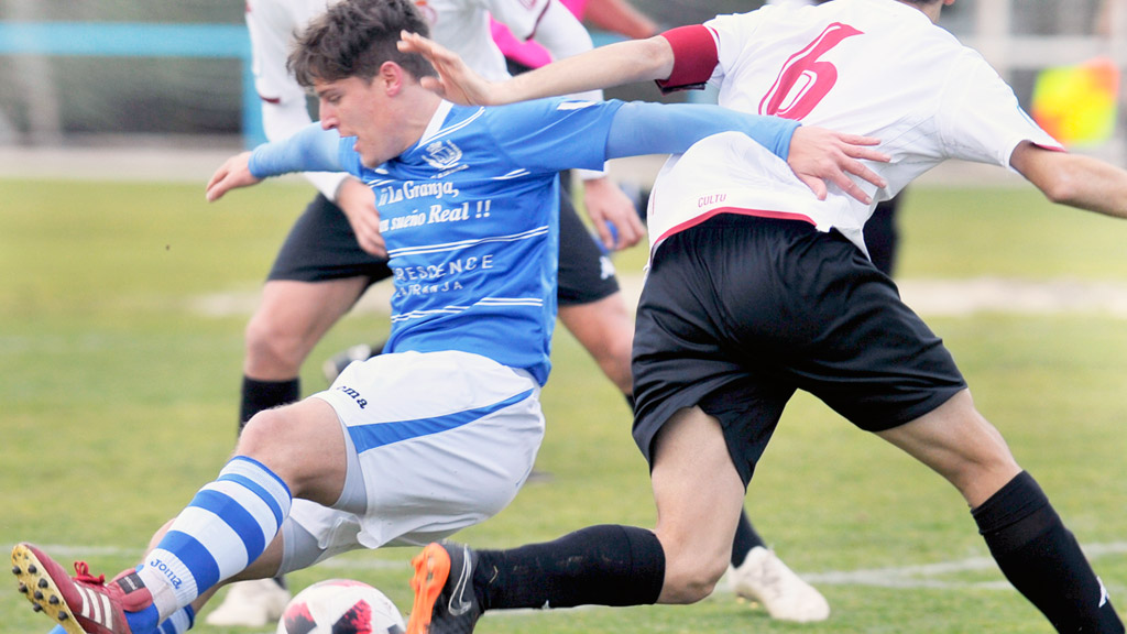 El delantero Dani Lázaro, duda para el partido de esta tarde, cae en un forcejeo con dos rivales del Júpiter. / KAMARERO