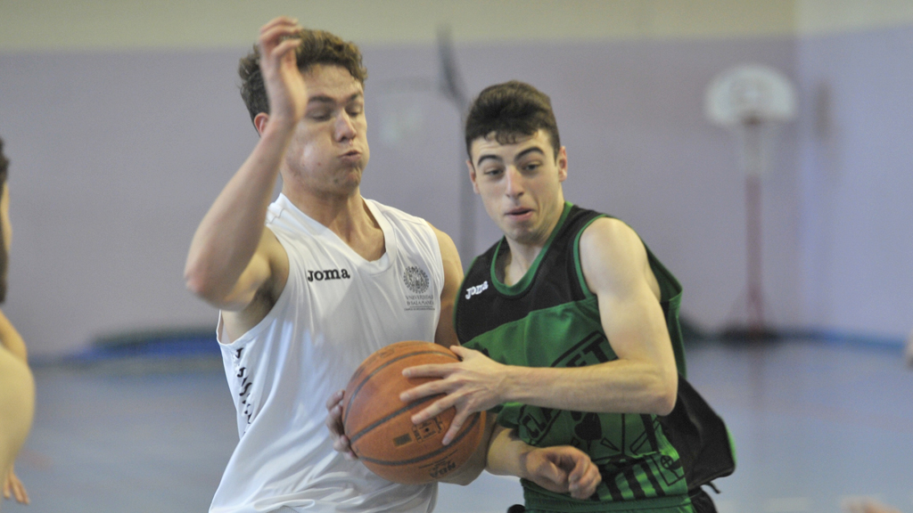 Un jugador del CD Claret se dispone a entrar a canasta ante la presión de un rival de la Universidad de Salamanca. / KAMARERO
