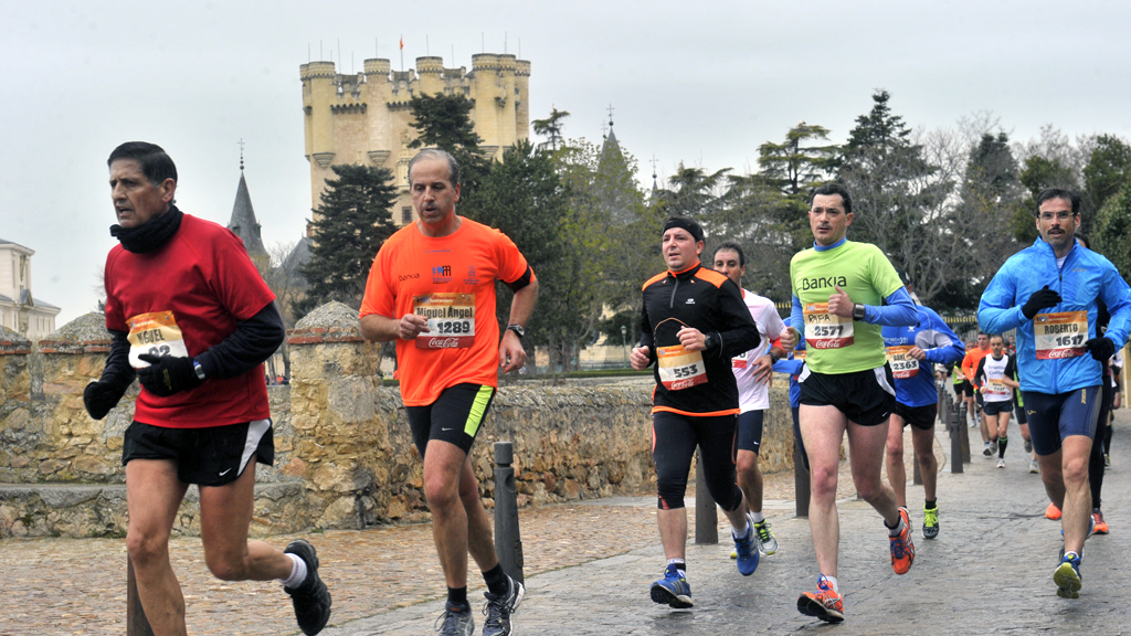Un grupo de corredores de una pasada edición de la media maratón de Segovia, con el Alcázar de fondo. / KAMARERO
