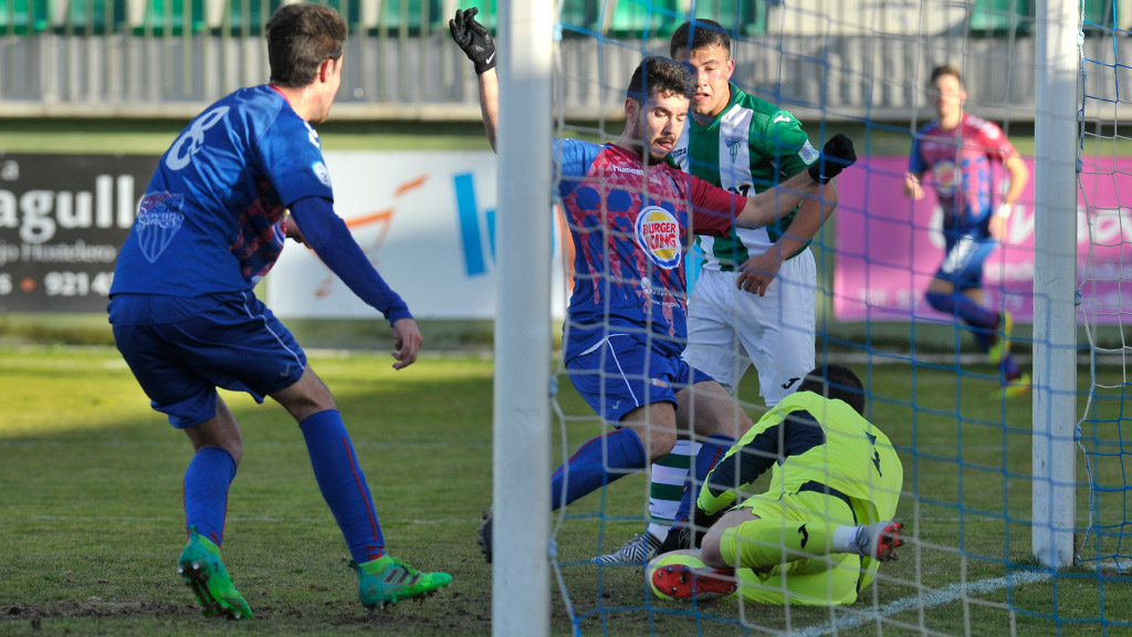 Mika intenta golpear el balón después de que al portero de la Cebrereña se le escapara de las manos tras un saque de esquina botado por la Segoviana. / KAMARERO