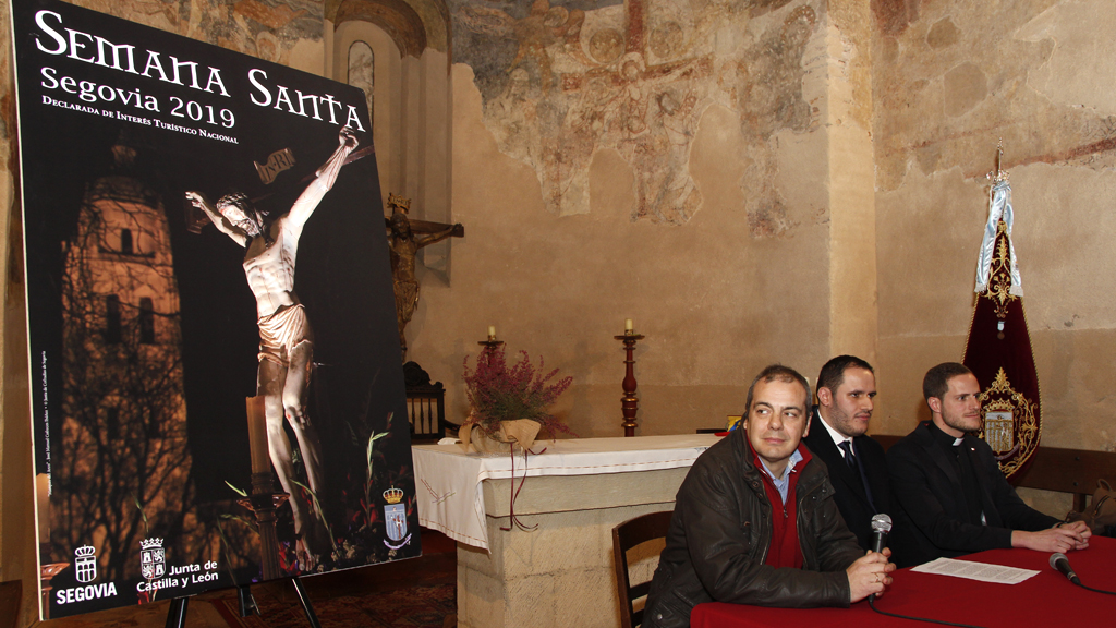 En la mesa, José Manuel Cofreces, Víctor López y Daniel Cuesta, junto al cartel anunciador de la Semana Santa./ NEREA LLORENTE